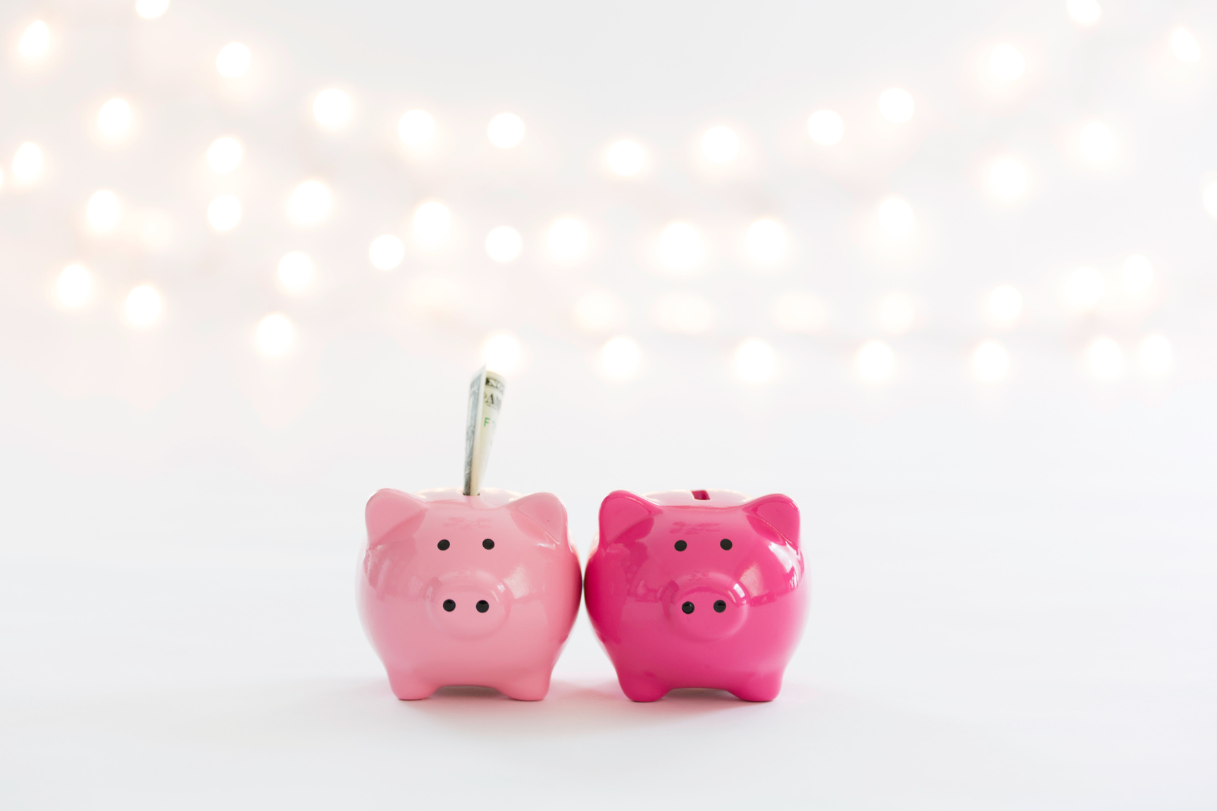 Two glossy pink piggies saving money